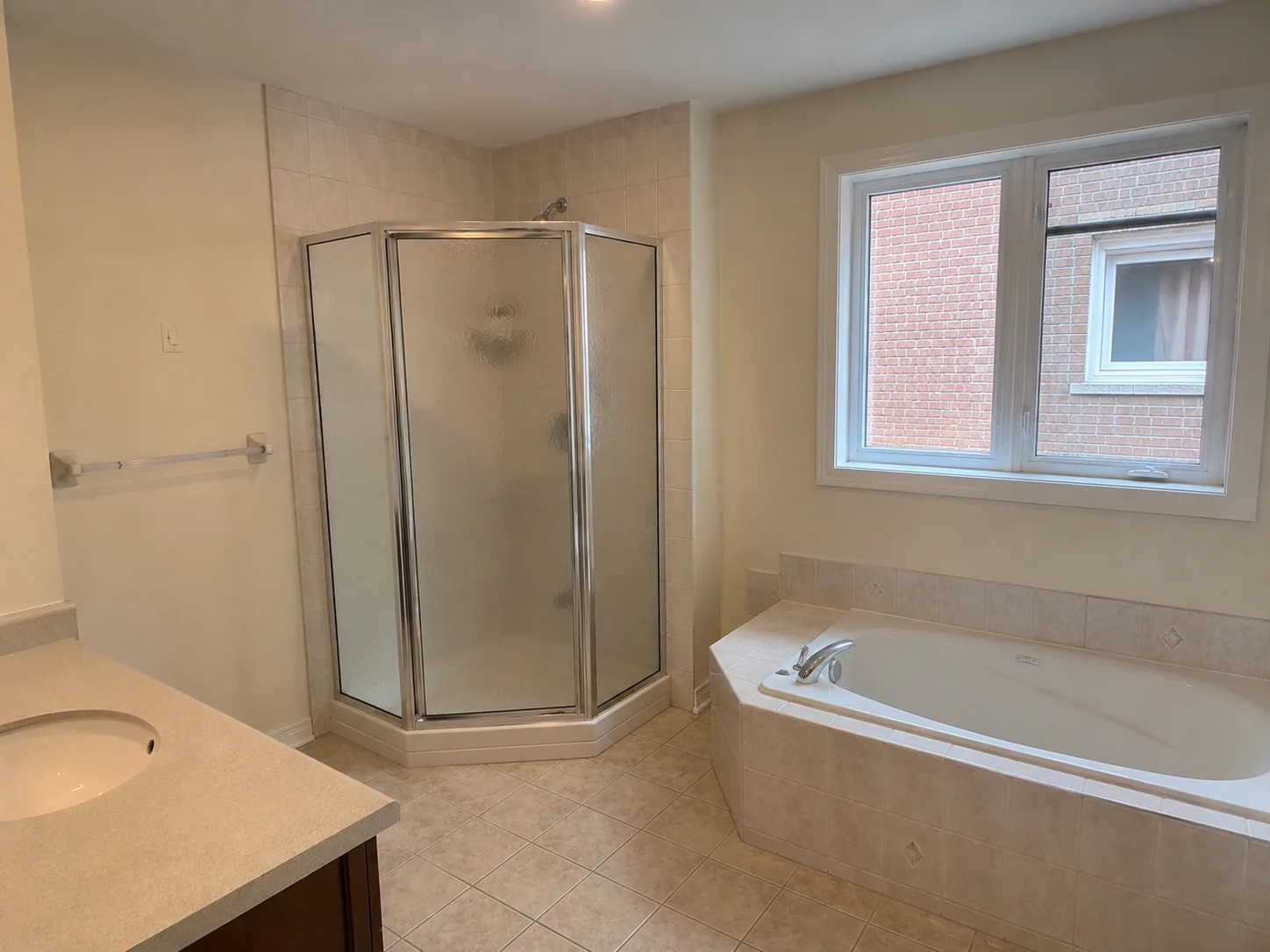 Bathroom before renovation: dated tub-and-shower combo with beige tile