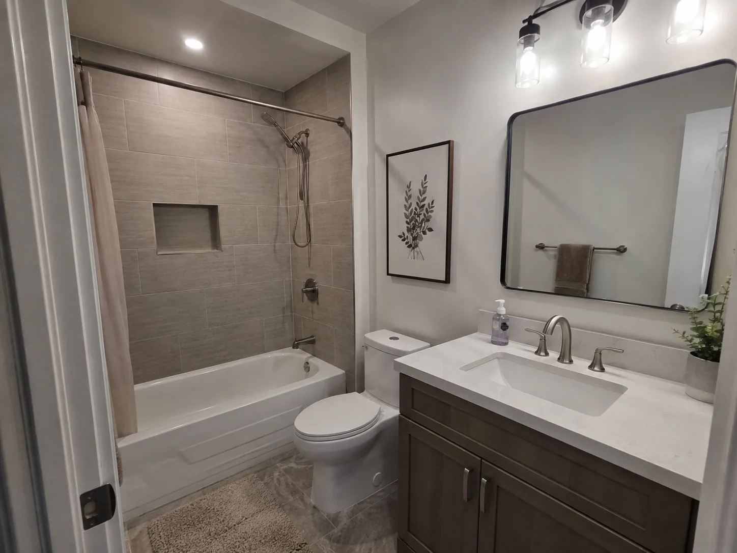 Family bathroom with tiled tub surround and quartz-topped vanity