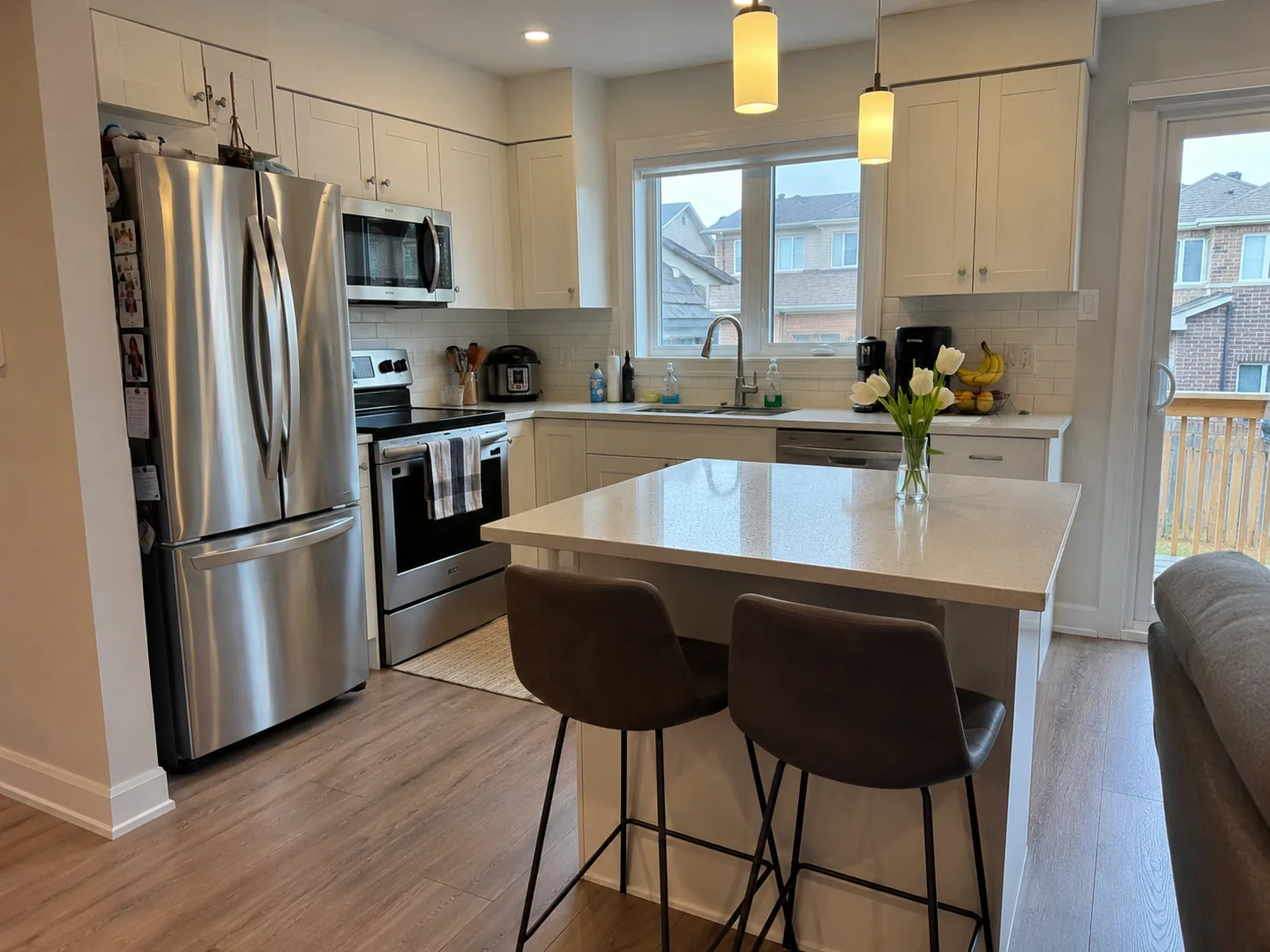Renovated kitchen with white cabinetry, quartz countertops, and a fresh island