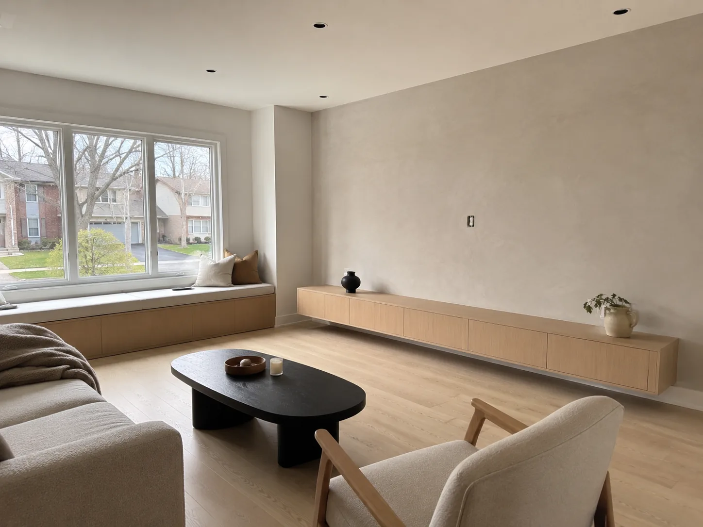 Minimalist living room with floating wood console and window bench